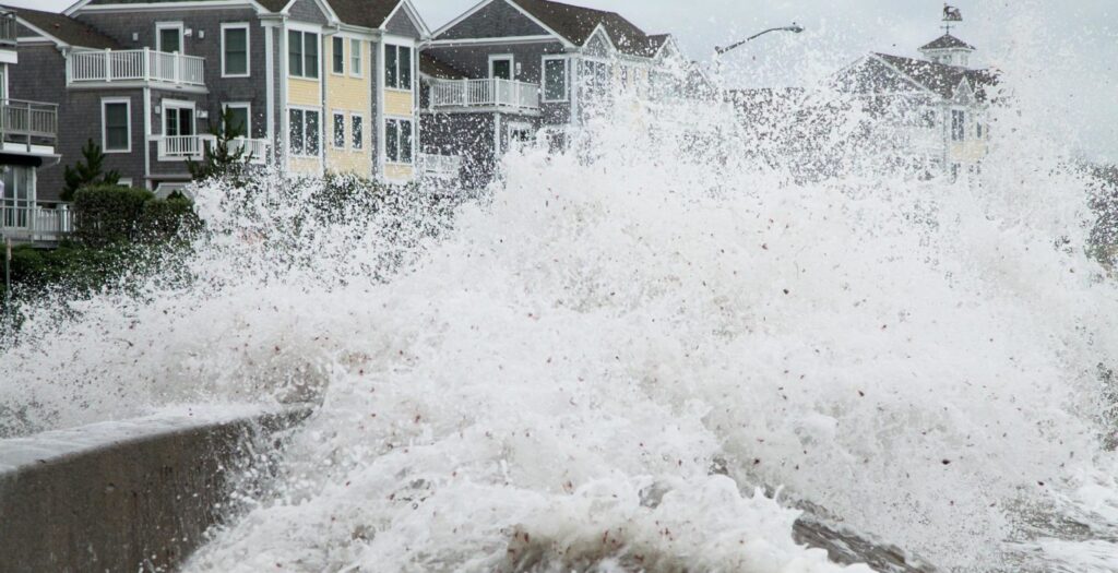 waves crashing on a pier of a residential area